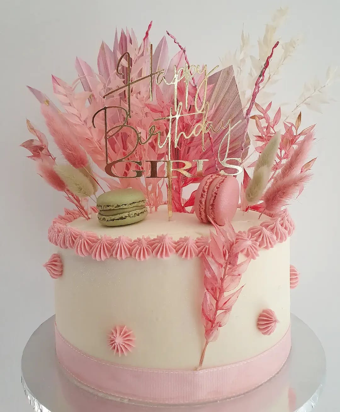 Pink birthday cake with macarons and a gold topper by Cupcake Tizzle
